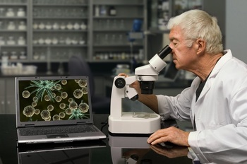 科学家在用显微镜研究细胞微生物