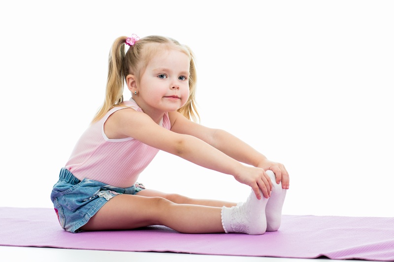 在瑜伽垫上锻炼身体的小女孩