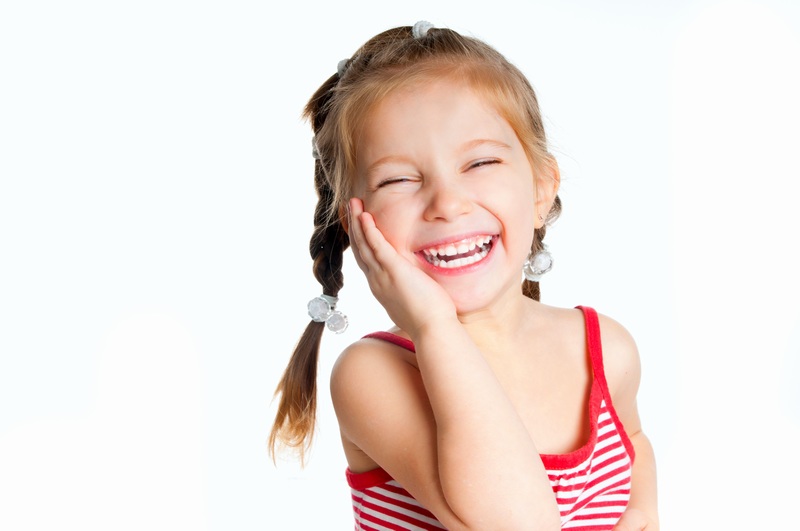 一个小女孩抚着脸开心的笑