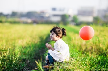 坐在草地上的孩子开心的笑