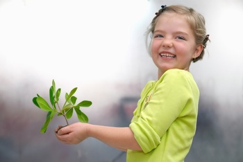 捧着一株植物的小女孩开心的笑