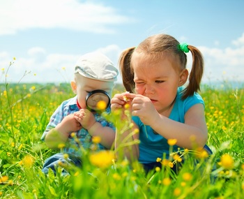 两个孩子用放大镜研究植物花草