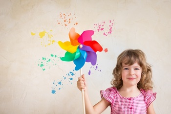 一个小女孩举着一个彩色的风车