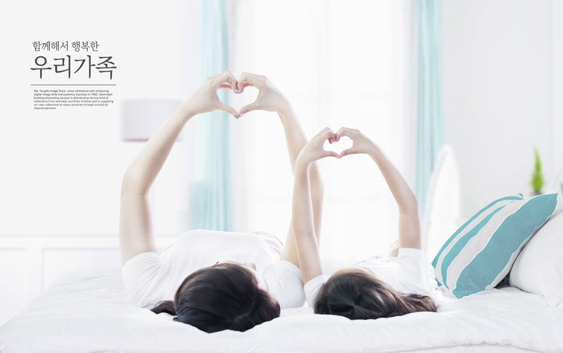 母女两人躺在床上用手比出心形的温馨场面ps广告素材